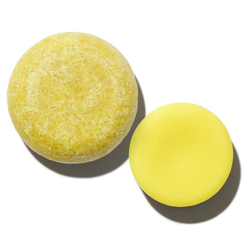 Two yellow balls of different textures and sizes on a white surface.