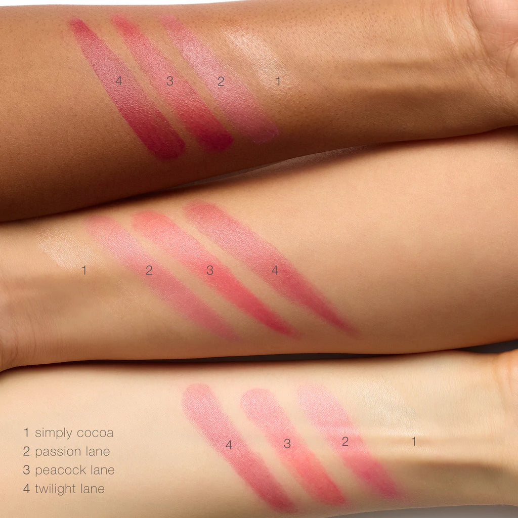 Swatches of four lipstick shades on three different skin tones.