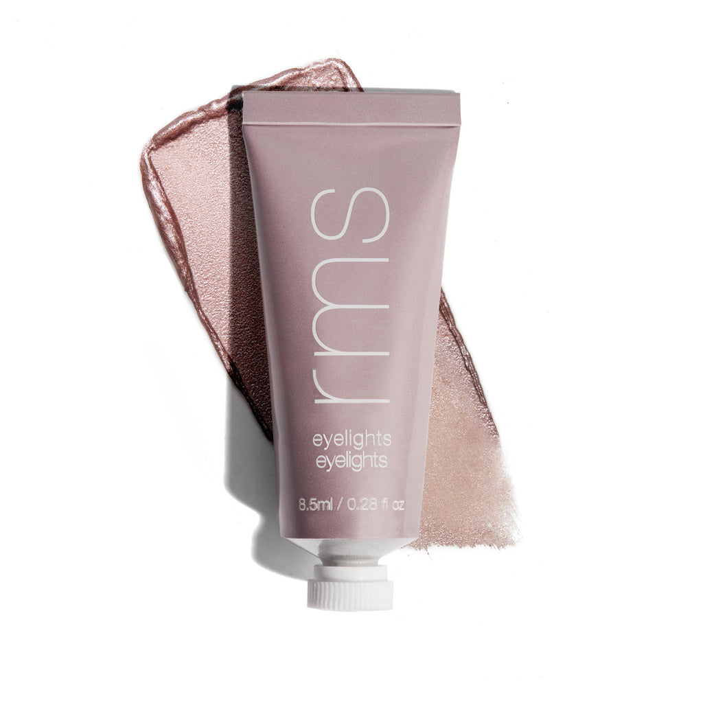 Cosmetic tube labeled "rms beauty eyelights" with a shimmery product smear and ribbon on a white background.