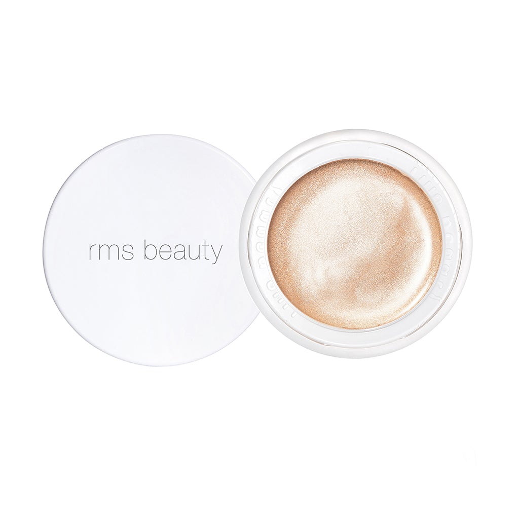 Open container of rms beauty highlighter with a white lid placed to the side.