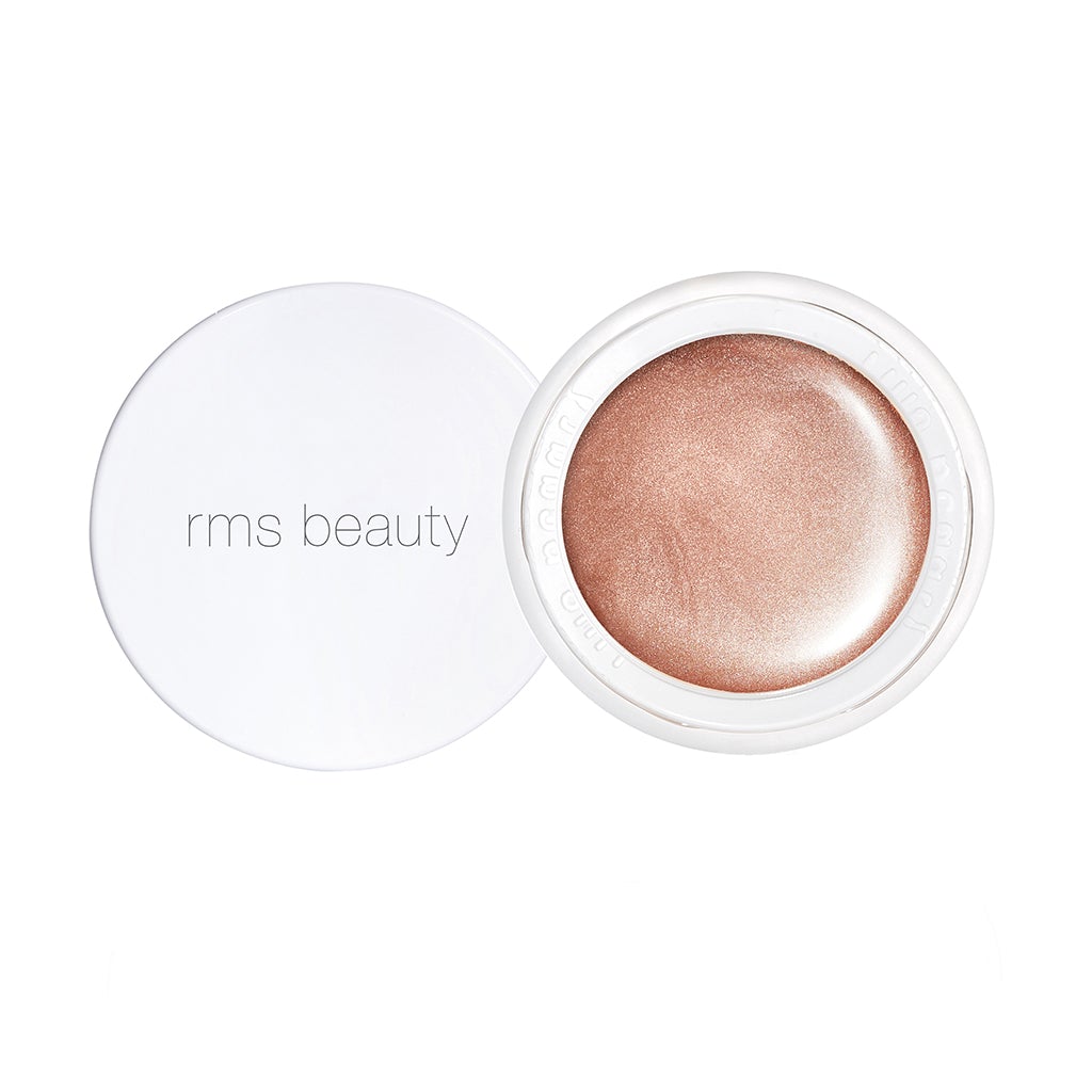 Open container of rms beauty cream highlighter with cap beside it.