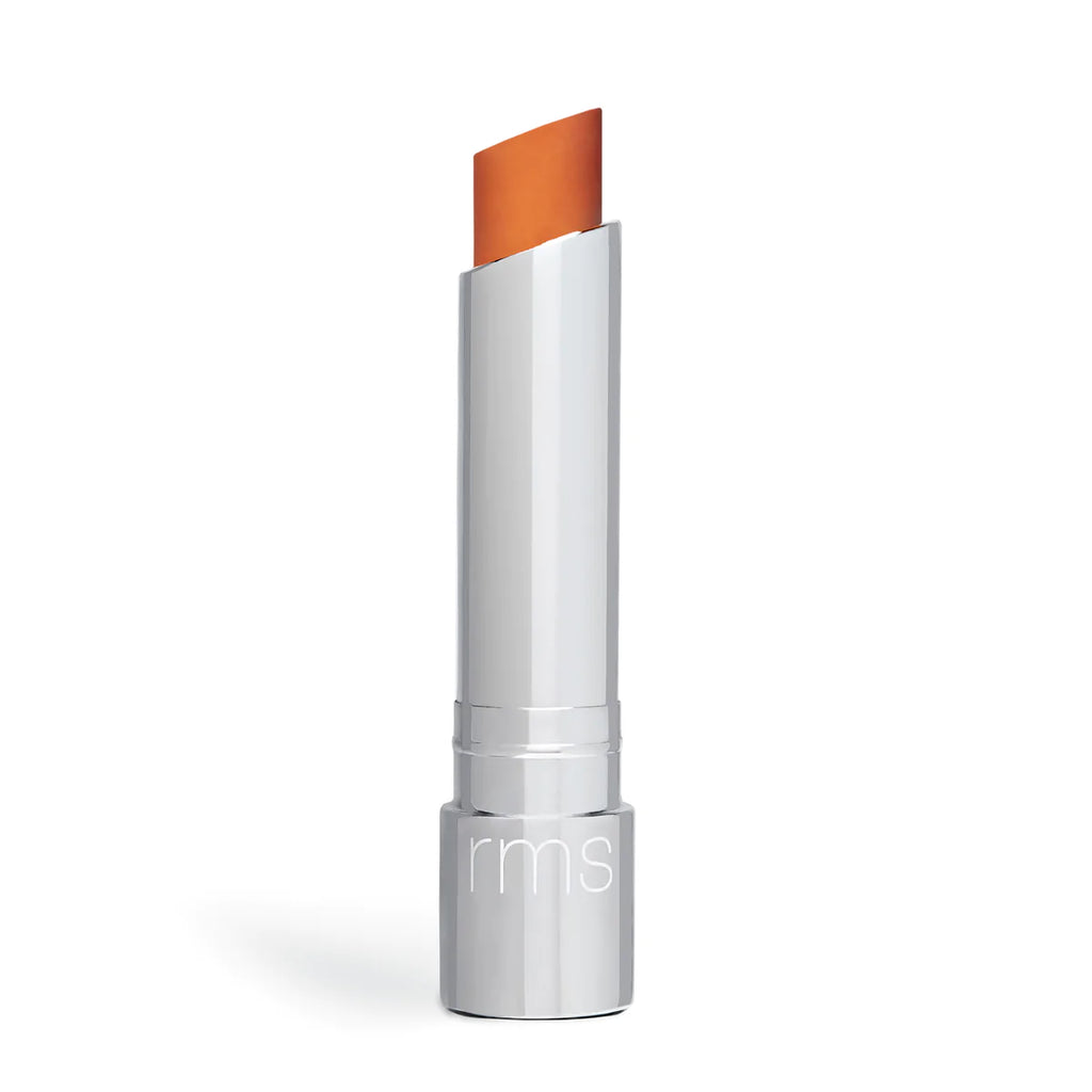 A single tube of lipstick with the cap off, revealing an orange shade, isolated on a white background.