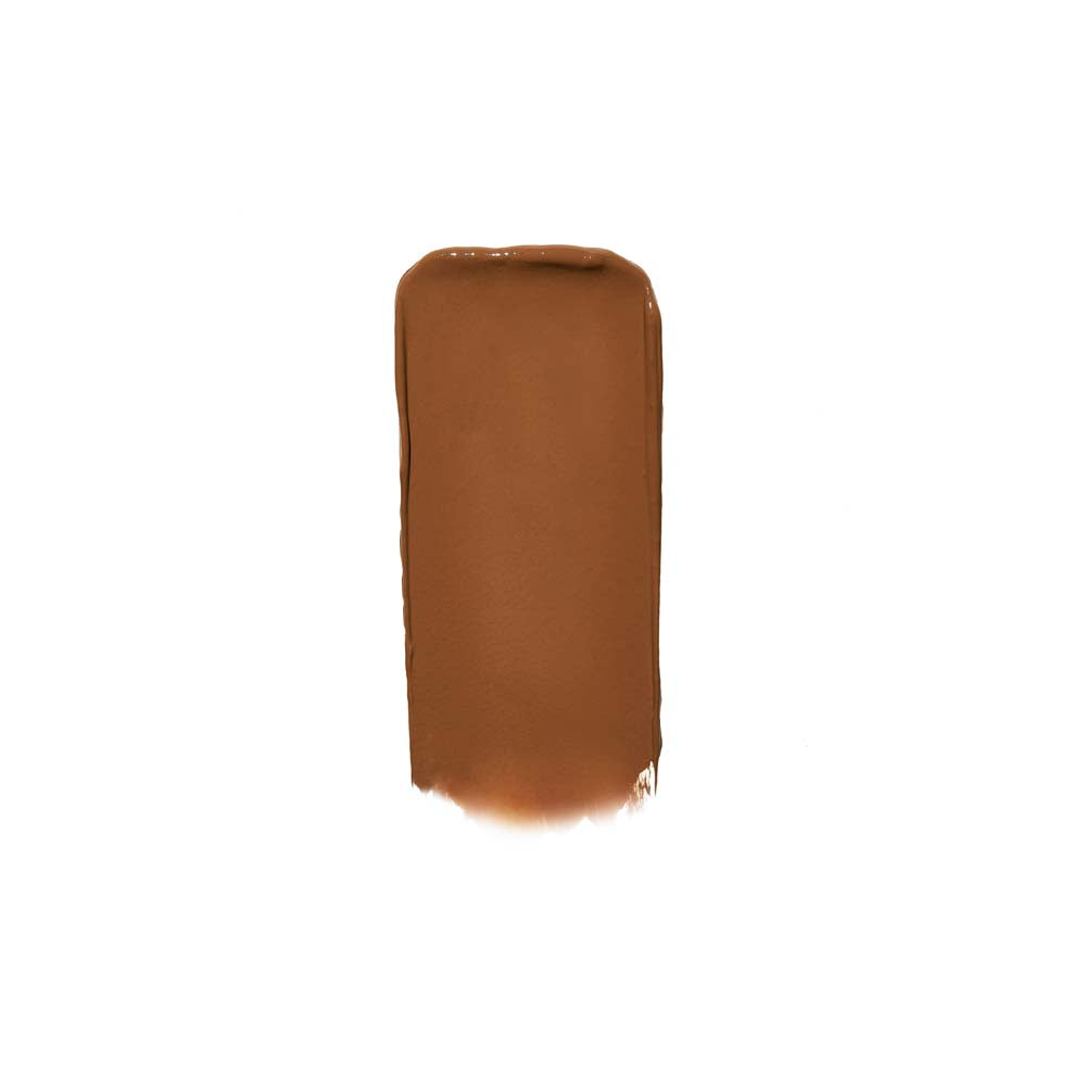 A swatch of brown liquid cosmetic product, possibly foundation or concealer, against a white background.
