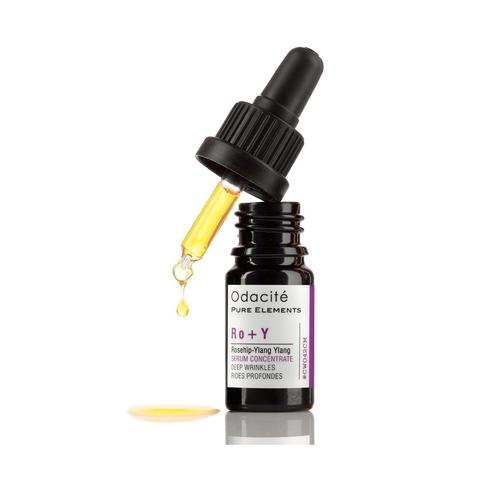 Dropper bottle of odacite ro+y rosehip-ylang ylang deep wrinkles serum concentrate with a single drop suspended mid-air.