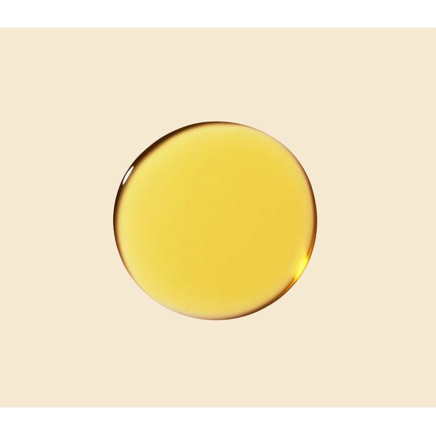 A drop of golden liquid centered on a beige background.