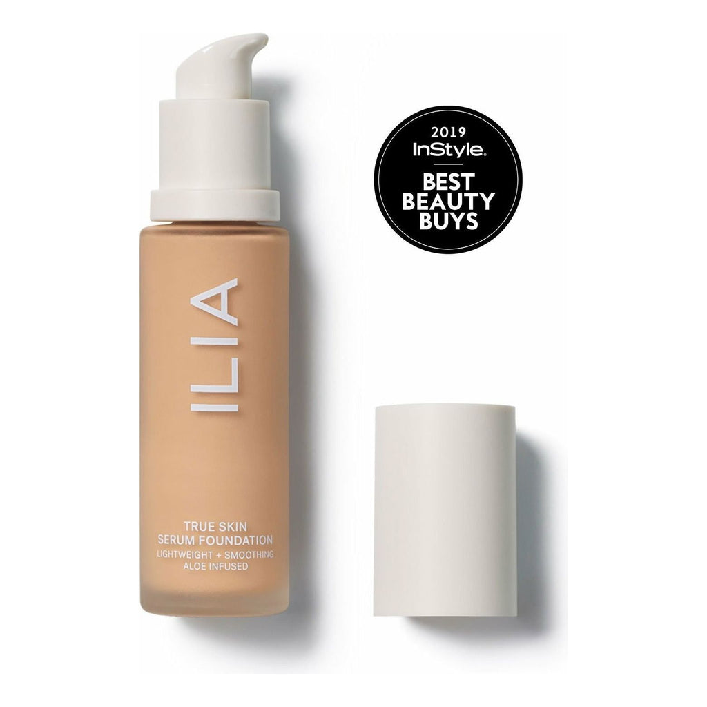 A bottle of ilia true skin serum foundation with a pump dispenser and its cap placed beside it, displaying an instyle 2019 best beauty buys badge.