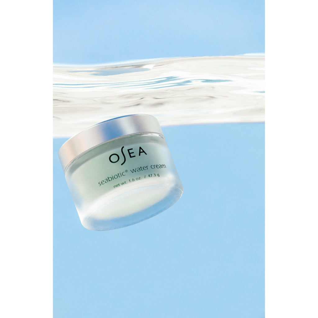 Container of osea seabiotic water cream floating serenely under water with a clear blue background.