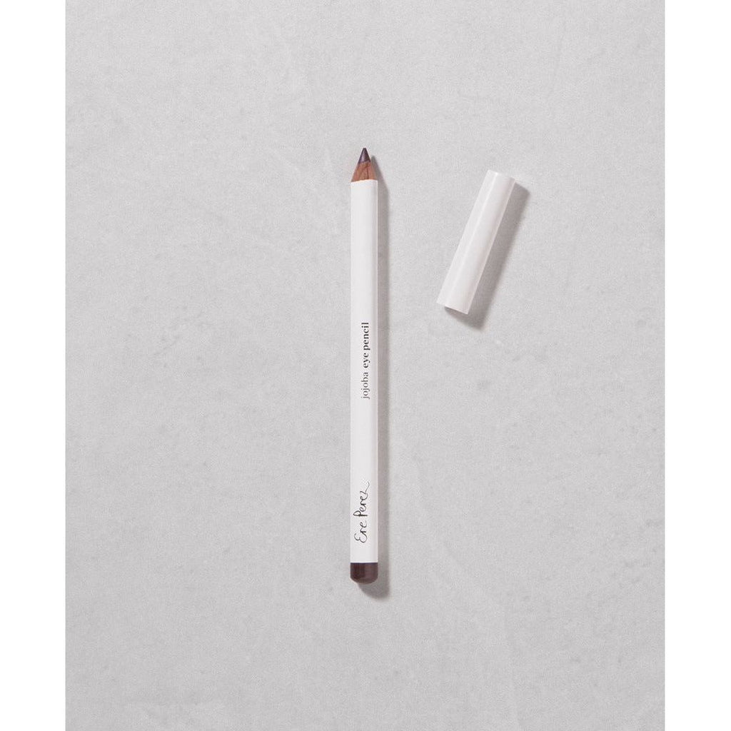 A white pencil with a protective cap placed beside it on a textured surface.