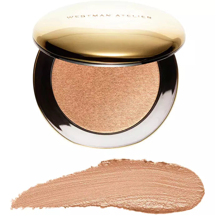 A compact case of westman atelier highlighter above a swatch of the product applied on a surface, showing its texture and color.