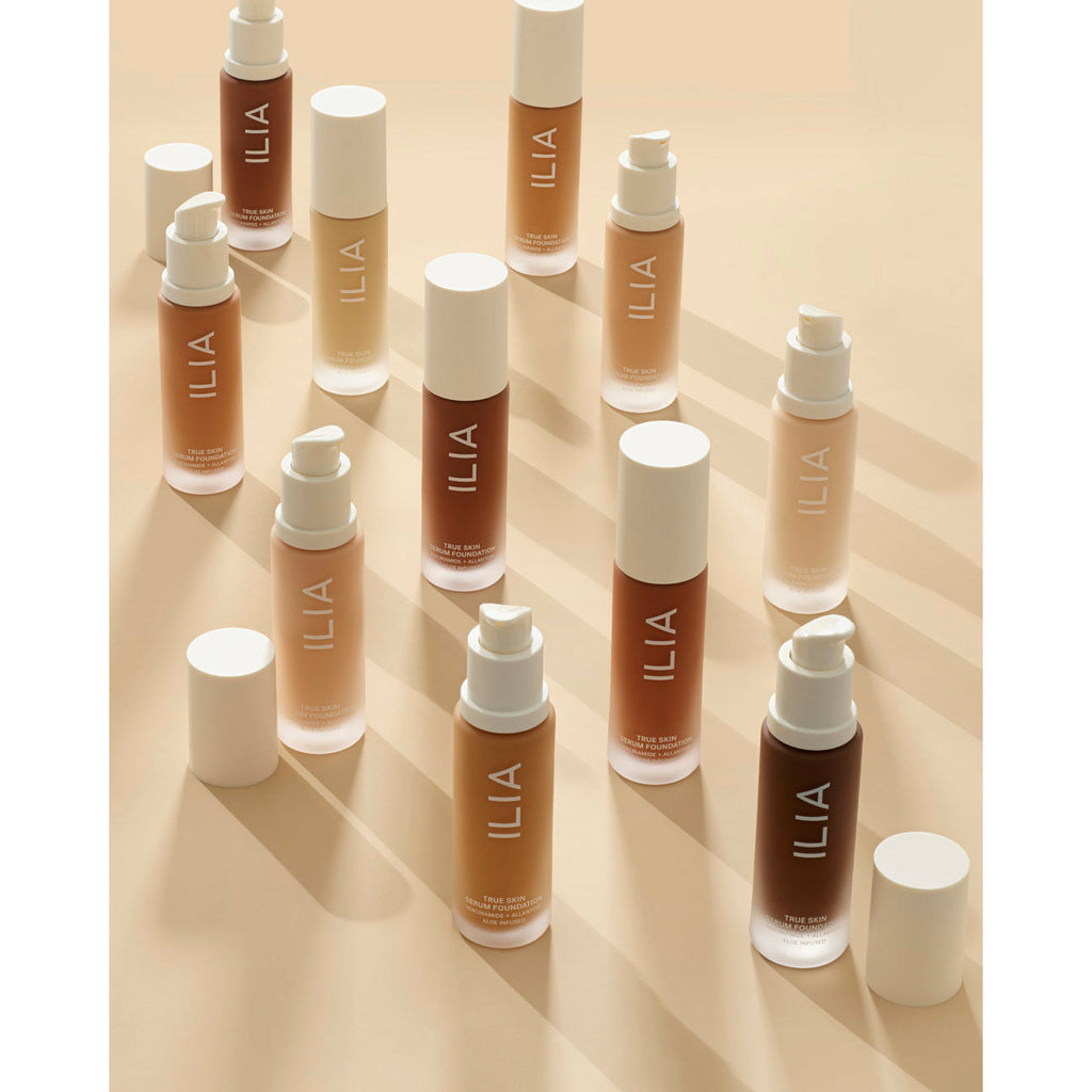 An array of neatly arranged cosmetic bottles with various shades of foundation.