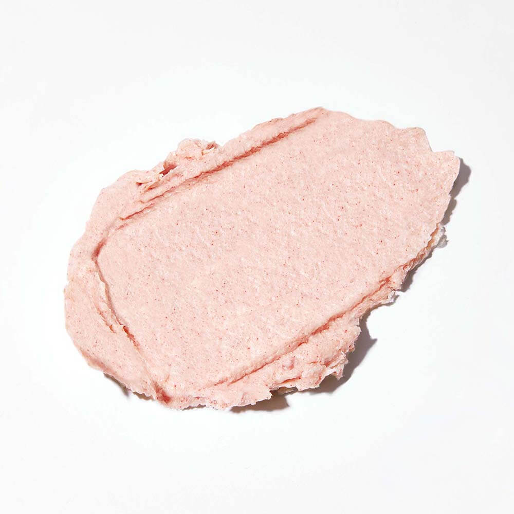A dollop of pink, creamy substance on a white background.