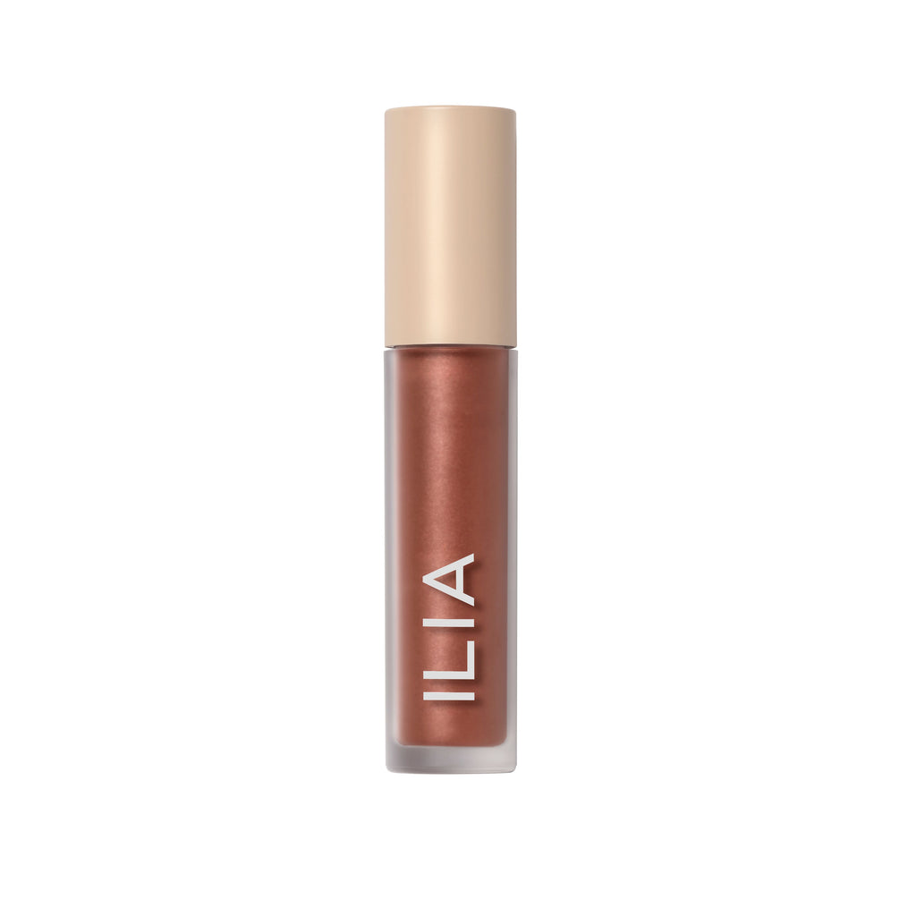 A tube of ilia brand lip gloss against a white background.