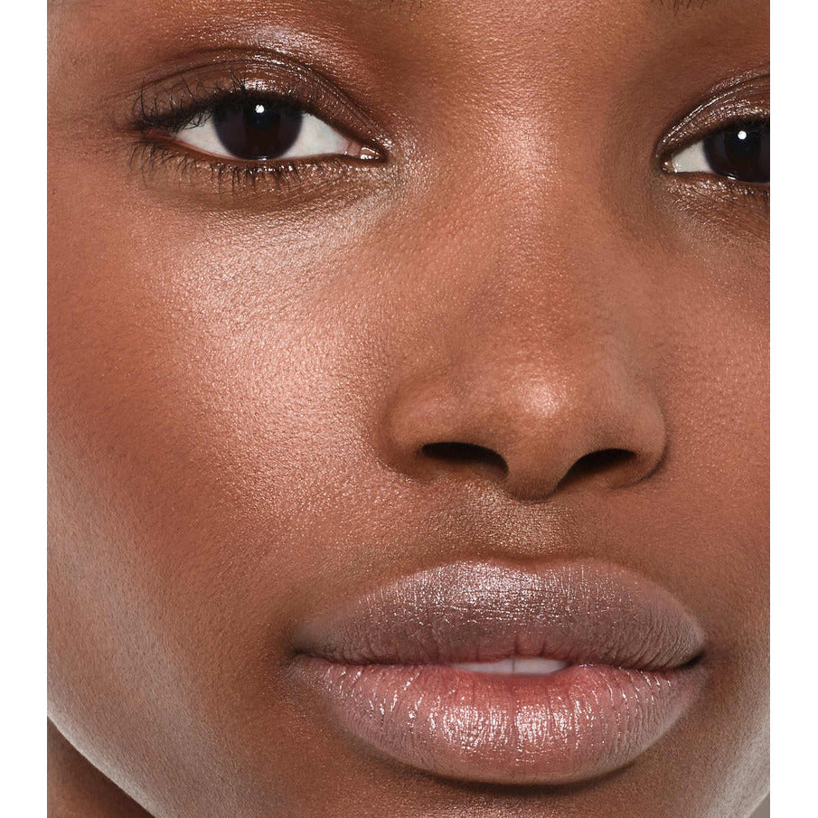 Close-up of a woman's face focusing on her natural skin texture, showcasing her eyes, nose, and lips.