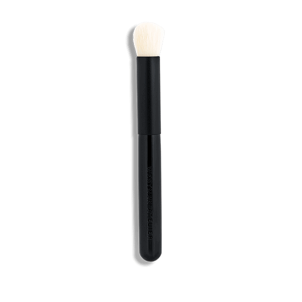 Black handled makeup brush with white bristles on a plain background.
