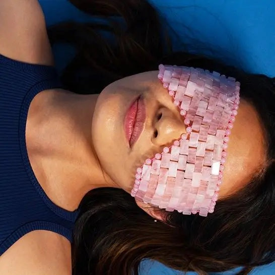 Woman with pink pixelated eyewear lying on a blue background.