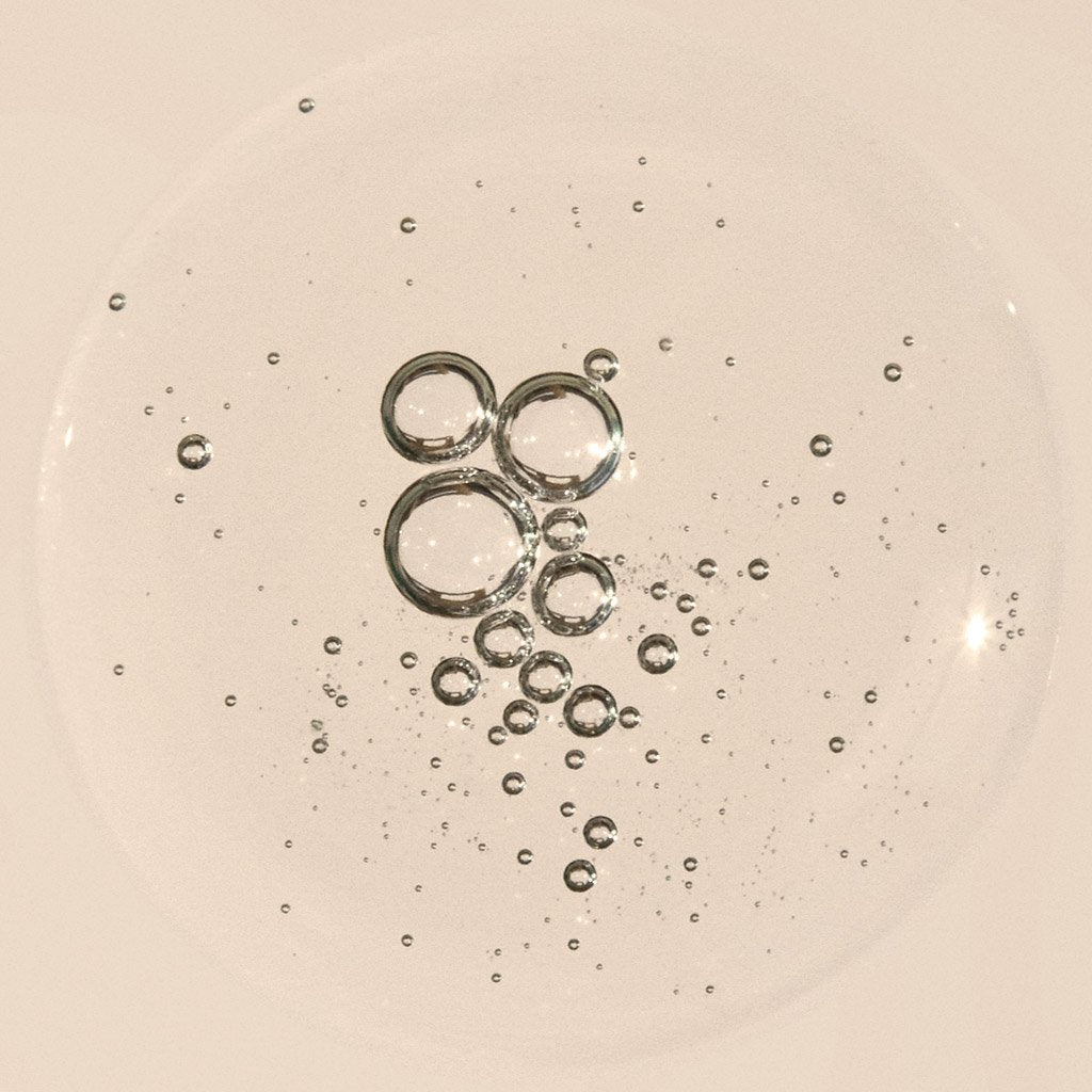 Bubbles of varying sizes clustered together on a liquid surface.