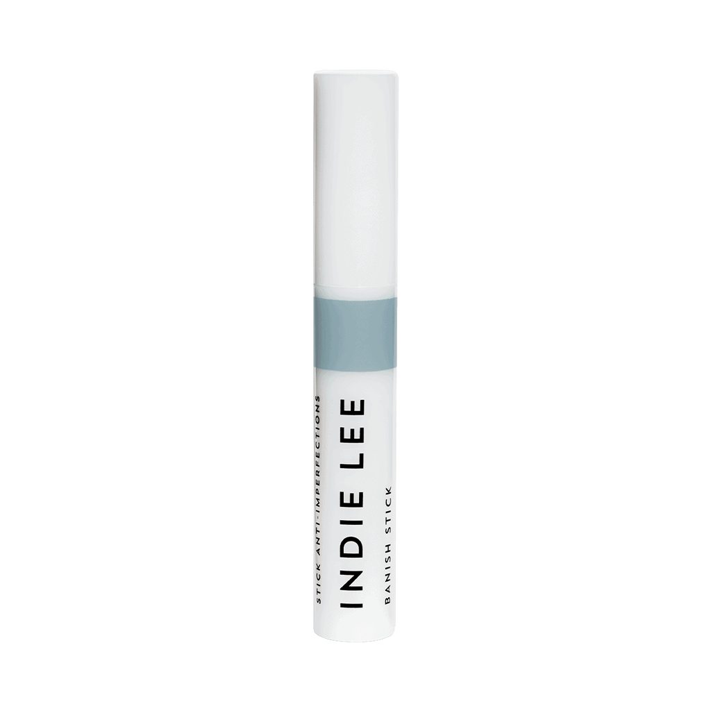 A tube of indie lee blemish stick against a white background.
