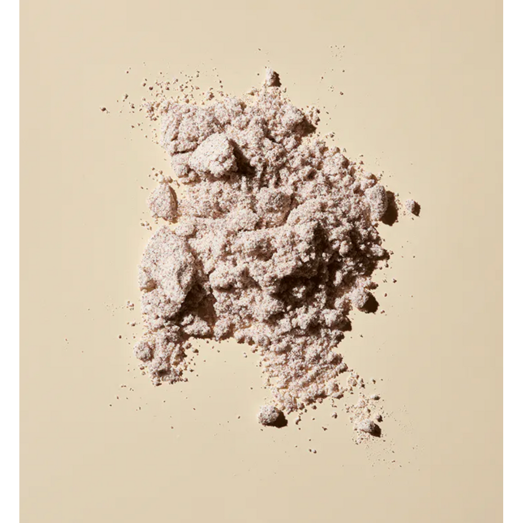 Loose powder makeup spilled on a beige surface.