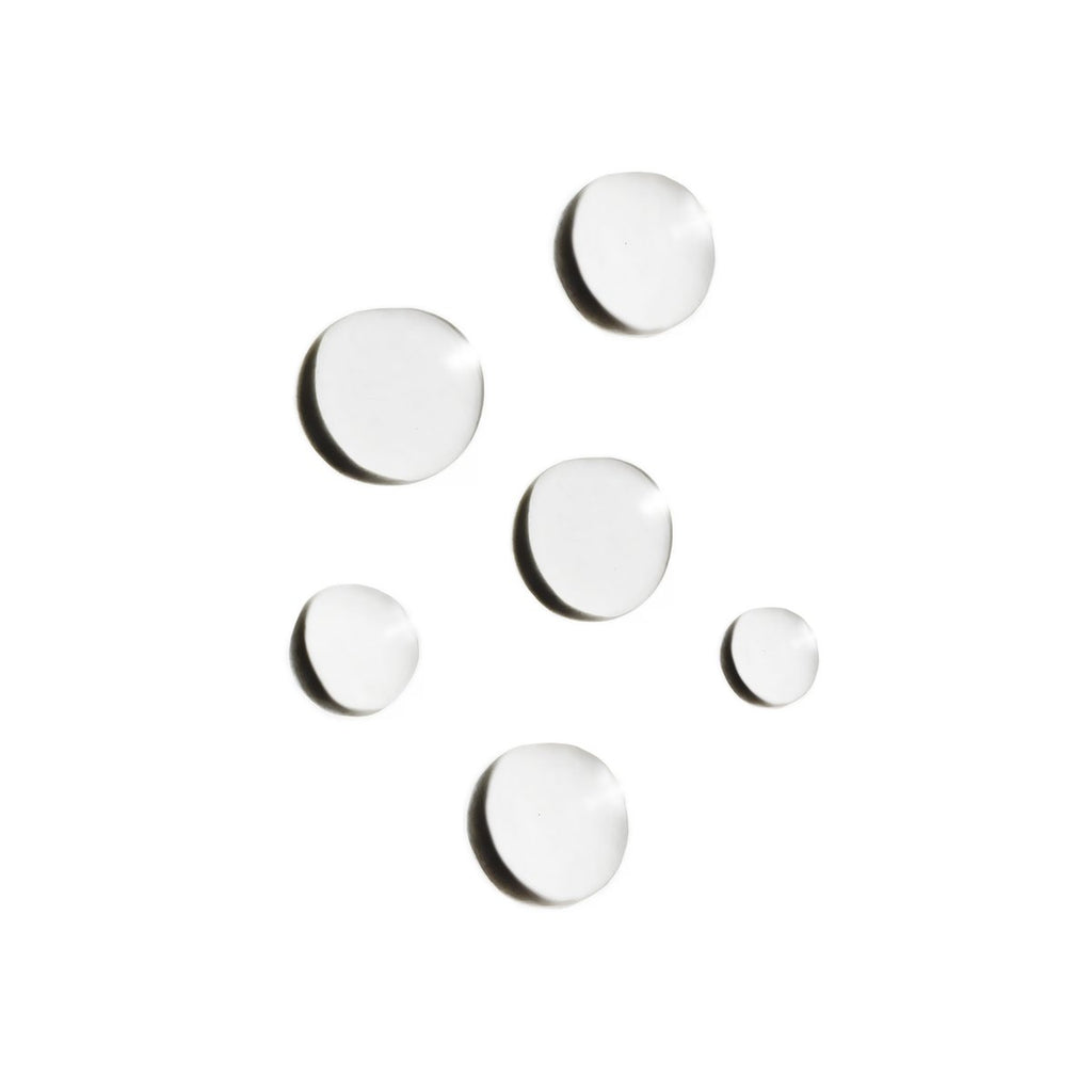 Seven round white pills or tablets scattered on a white background.