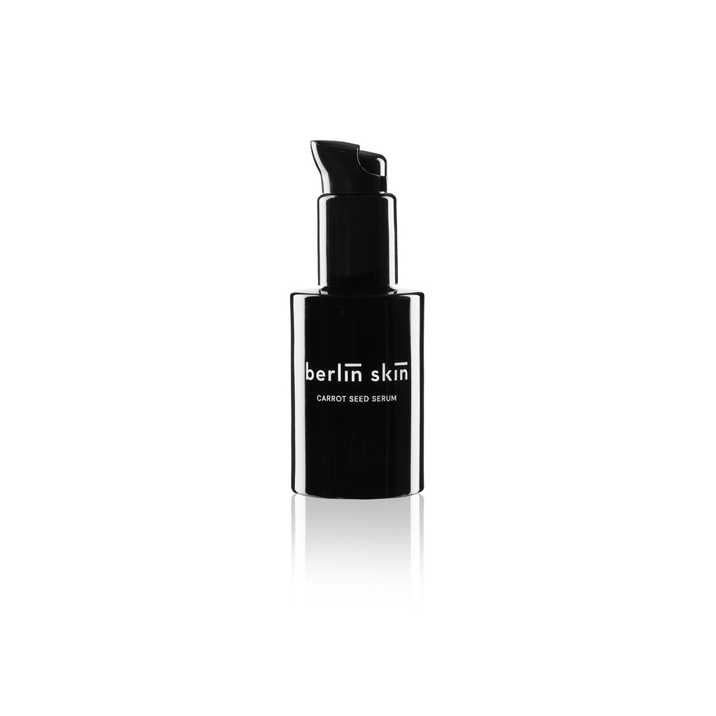 Black bottle of berlin skin carrot seed serum with a pump dispenser on a white background.