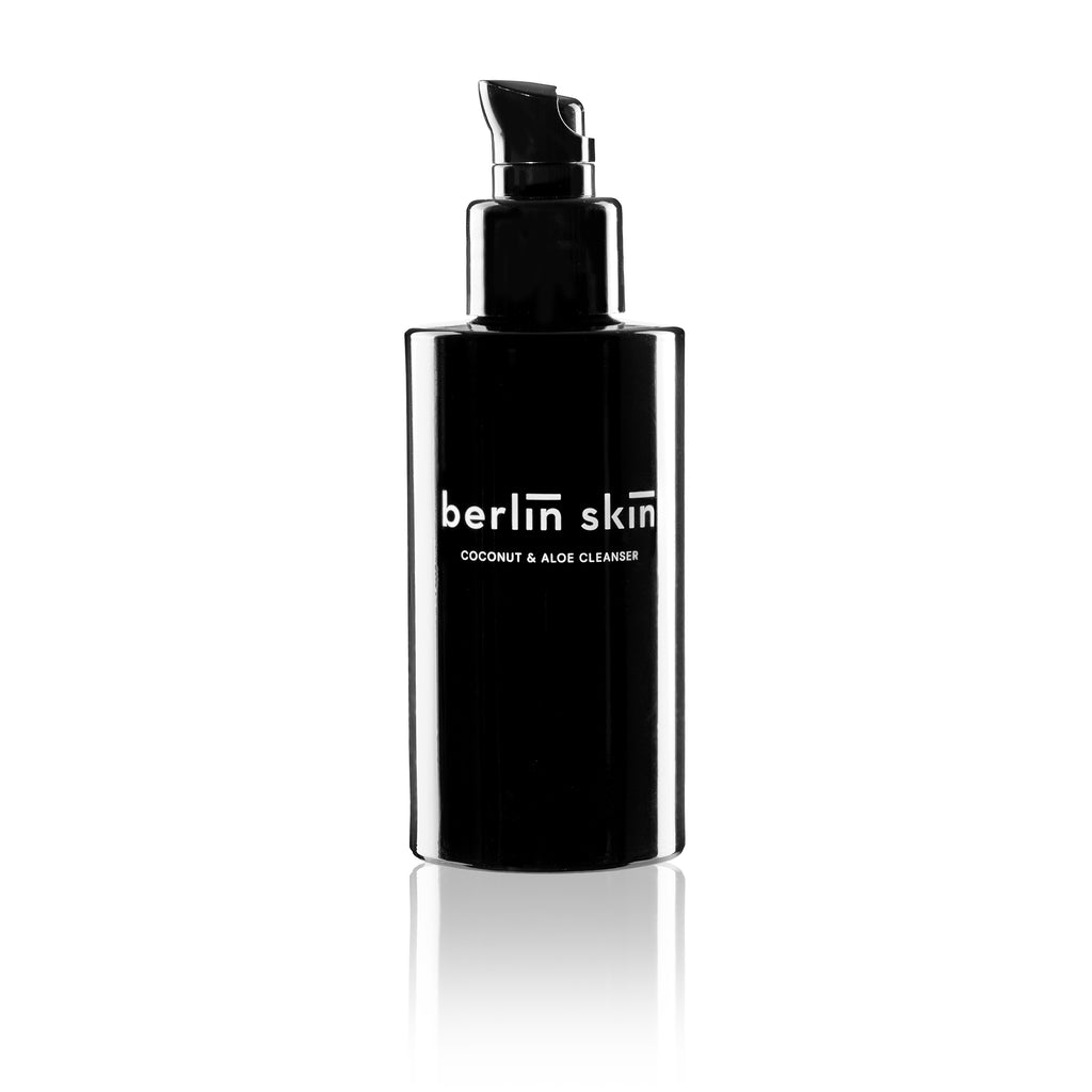 A black pump bottle labeled "berlin skin - coconut & algae cleanser" on a white background.