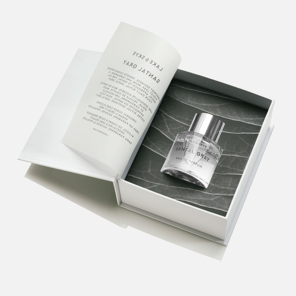 A bottle of santal 33 perfume by le labo presented in an open, elegant box with a marble design.