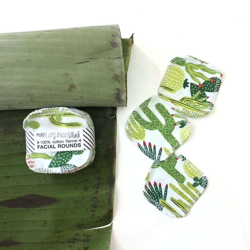 Eco-friendly reusable cotton facial rounds with a cactus print alongside a green leaf.