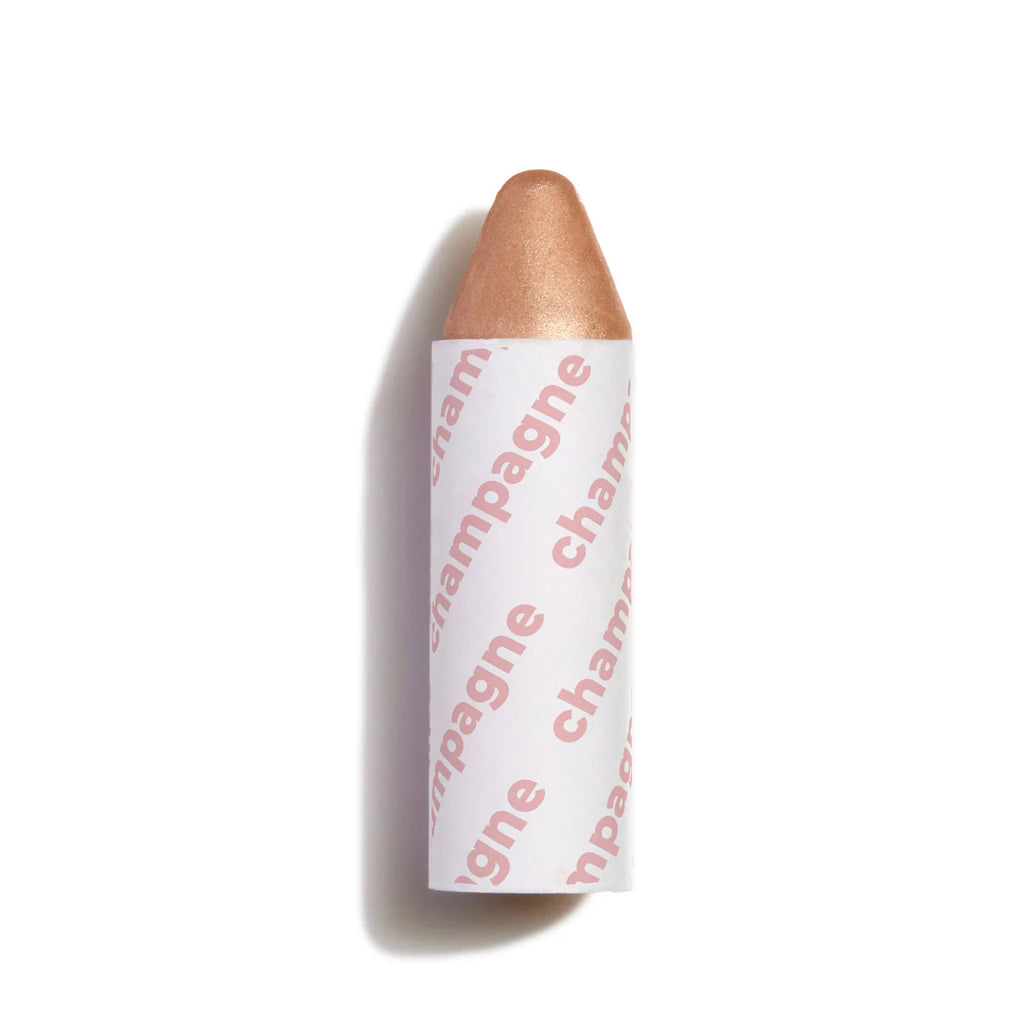 A single cosmetic highlighter stick with the word "champagne" printed on its label, set against a plain white background.