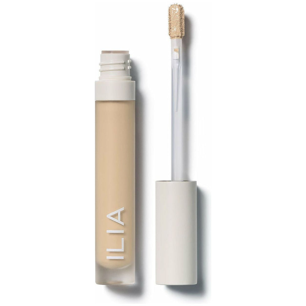 Ilia brand concealer with an open cap and applicator on a white background.