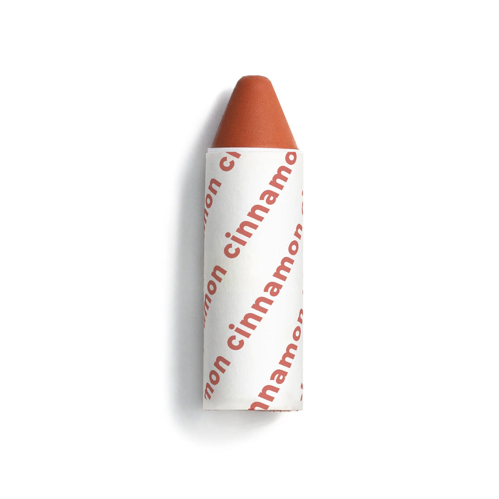 A single cinnamon-flavored crayon isolated on a white background.