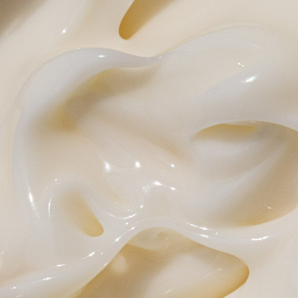 Close-up texture of a creamy white substance with glossy highlights.