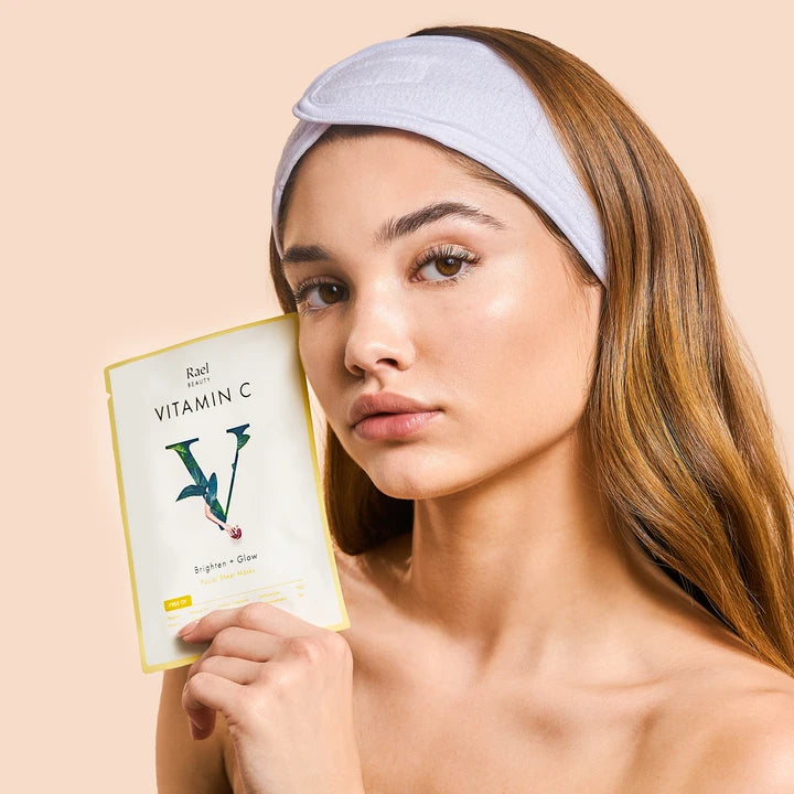 Woman holding a vitamin c skincare product.