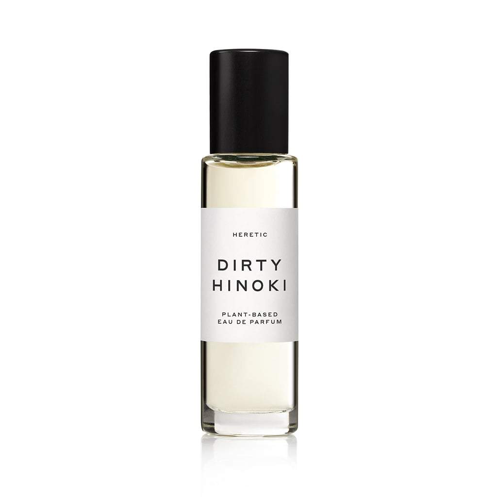 Bottle of "dirty hinoki" plant-based eau de parfum by heretic on a white background.