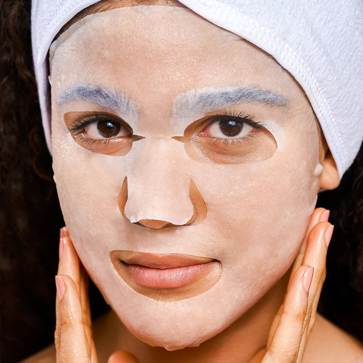 Woman wearing a facial sheet mask with under-eye patches.