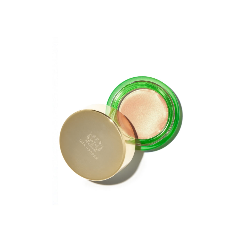Open compact powder with a golden lid on a white surface.