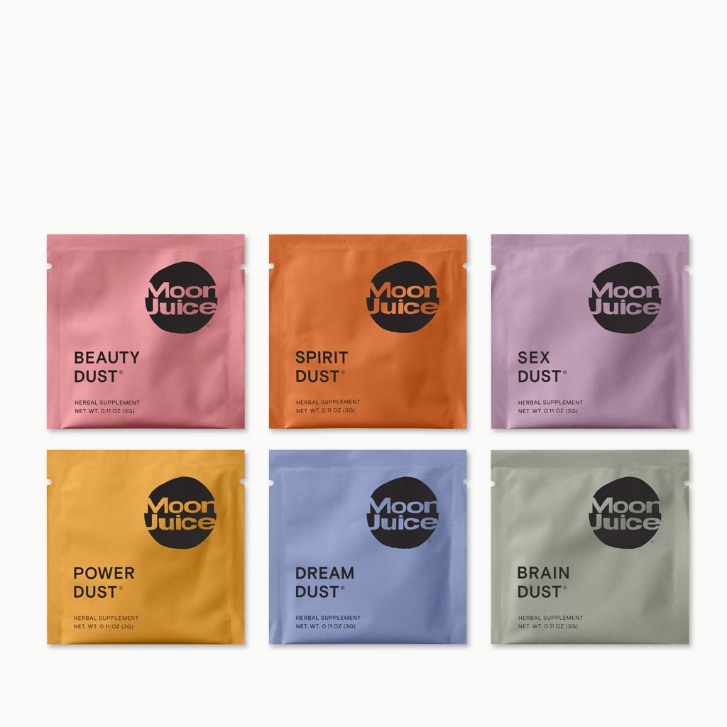 Six colorful packets of moon juice products with various supplement names like "beauty dust," "spirit dust," "sex dust," "power dust," "dream dust," and "brain dust.