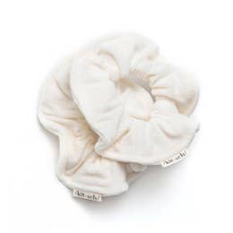 A single white fabric scrunchie on a white background.