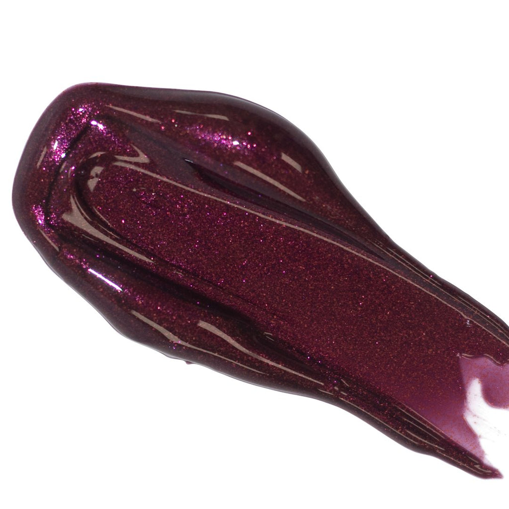 A swatch of sparkling burgundy nail polish on a white background.