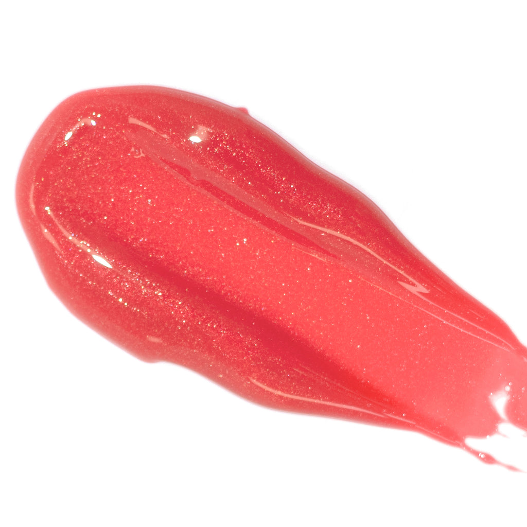 A smear of sparkling red lip gloss on a white background.