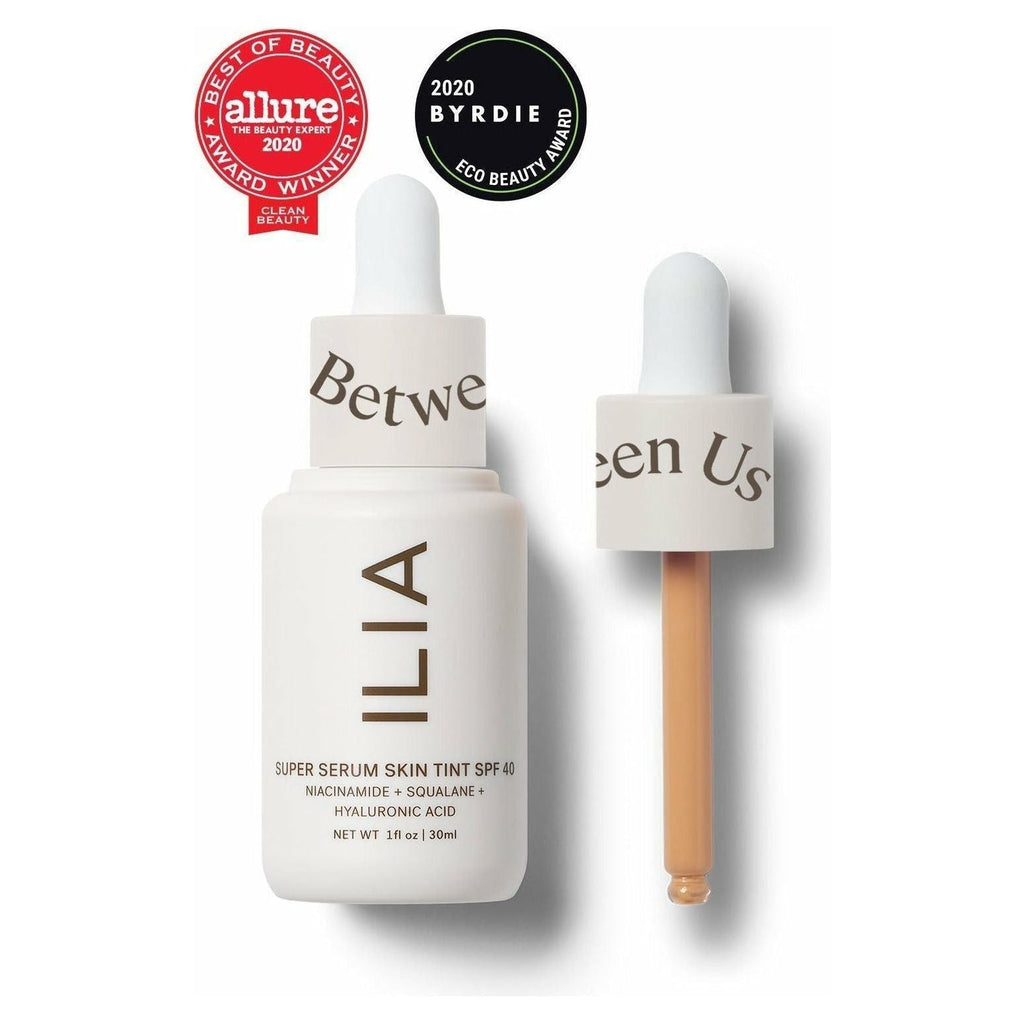 A bottle of ilia super serum skin tint spf 40 with its dropper applicator, displaying awards from allure and byrdie.