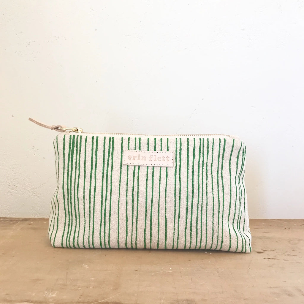 Striped fabric pouch with label on a plain background.