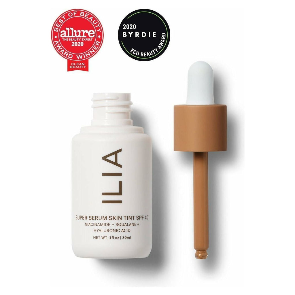 A bottle of ilia super serum skin tint with spf 40 alongside its dropper, highlighted by allure and byrdie beauty award badges.