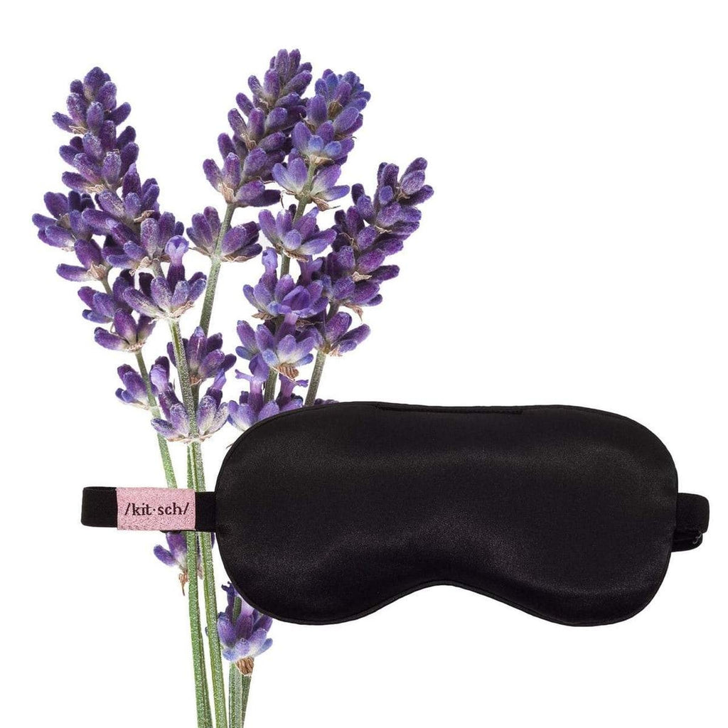 Artificial lavender flowers next to a black sleep mask.