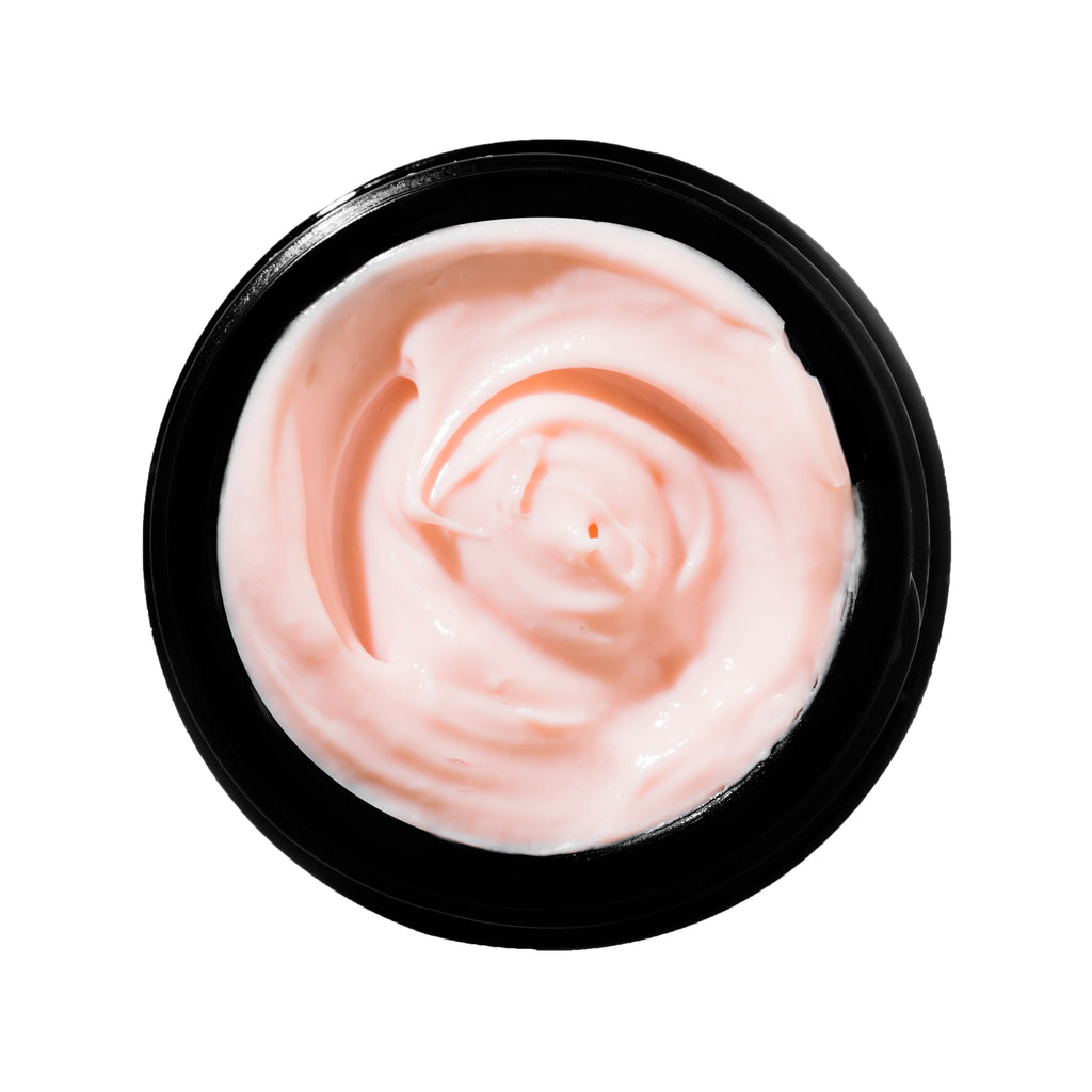 Top view of an open jar filled with pink cosmetic cream.