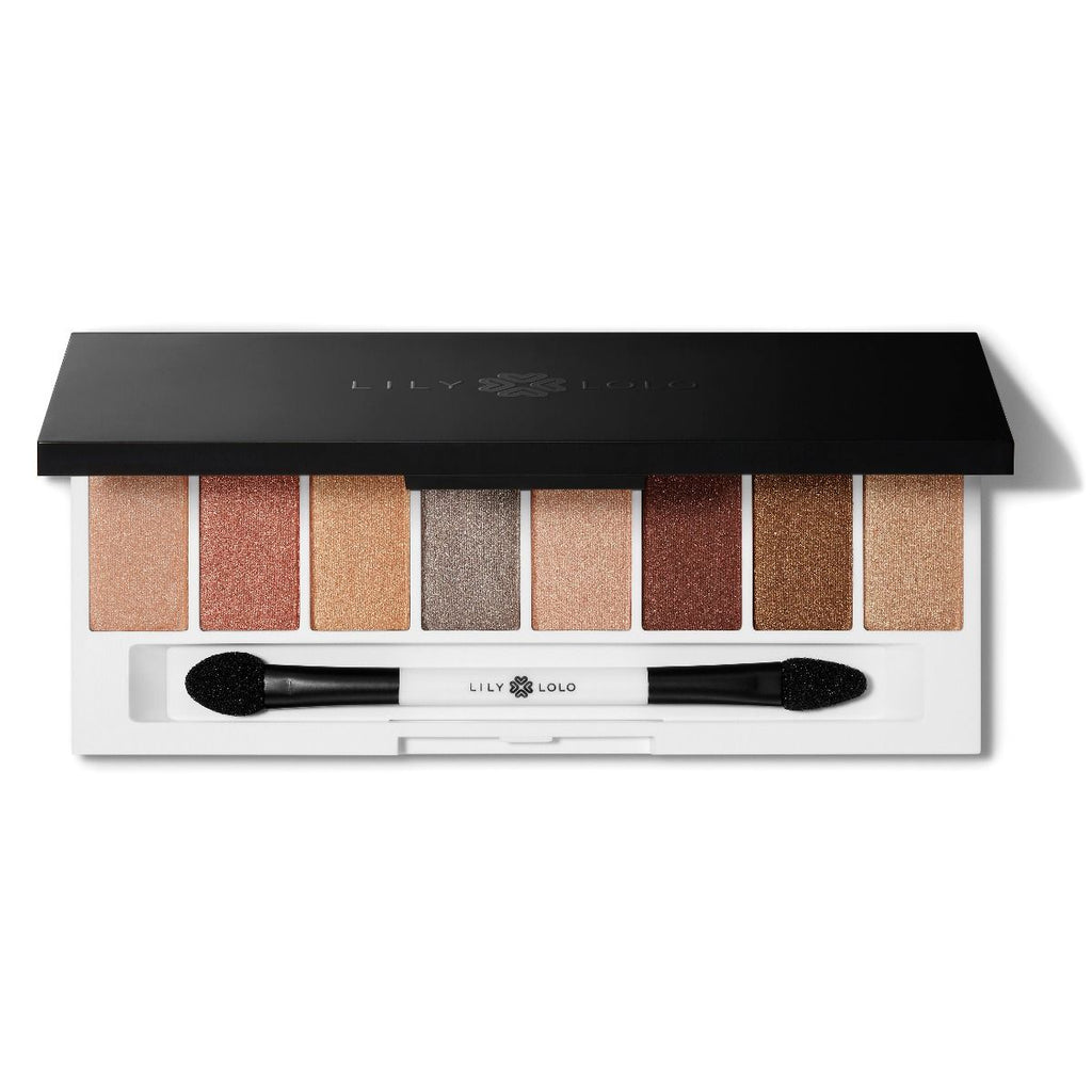 An eyeshadow palette with an array of neutral shades and a dual-ended brush.