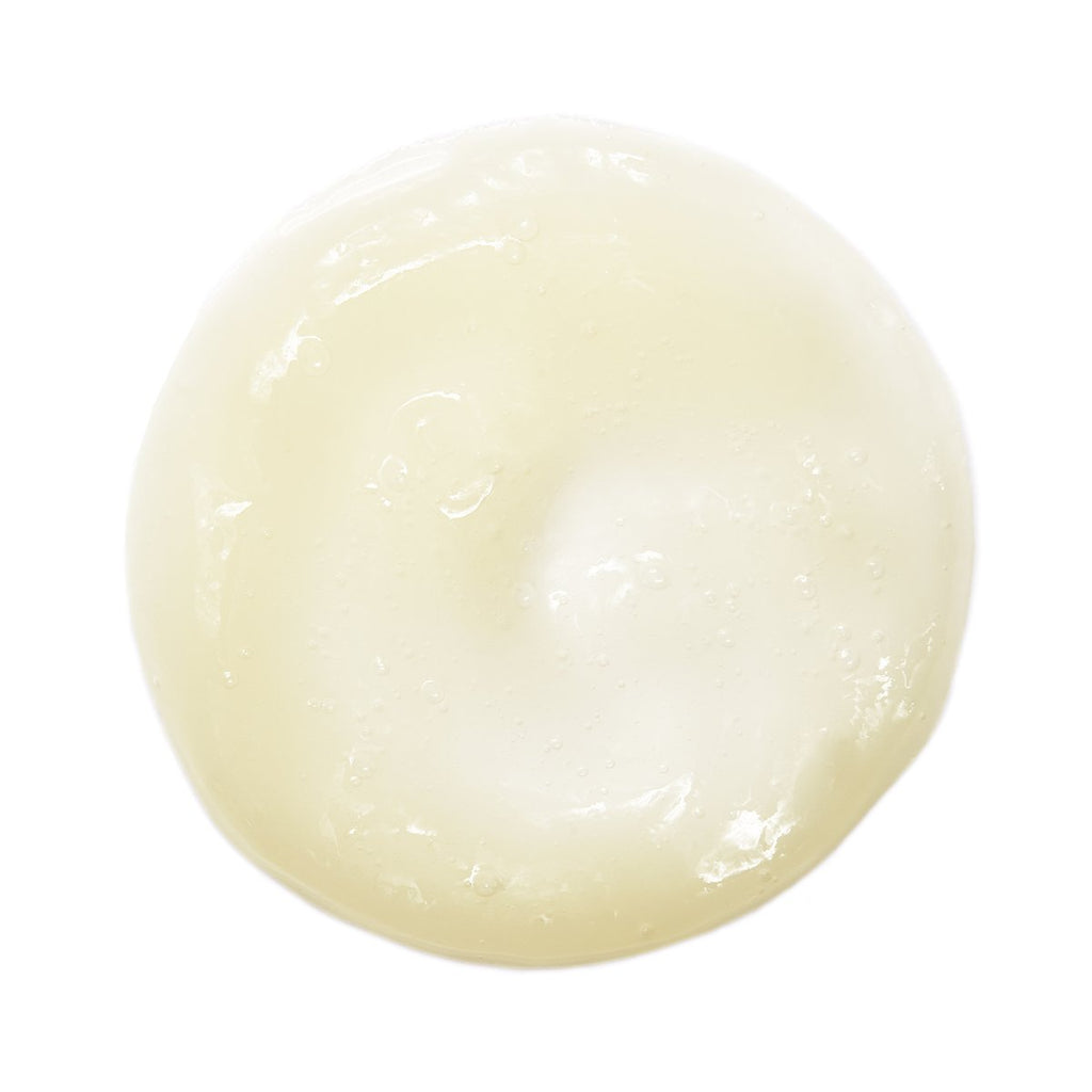 A single dollop of white cream or lotion on a white background.