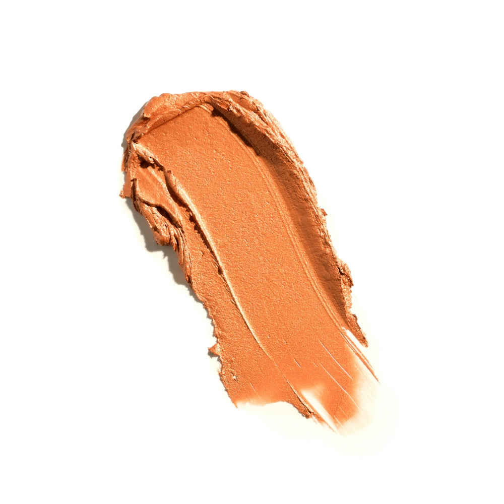 Swatch of creamy, orange-toned makeup product against a white background.