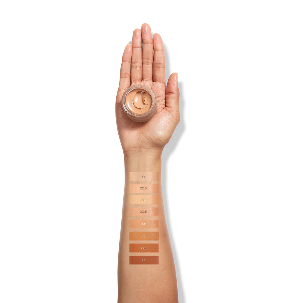 Various shades of foundation swatched on a forearm for color comparison.