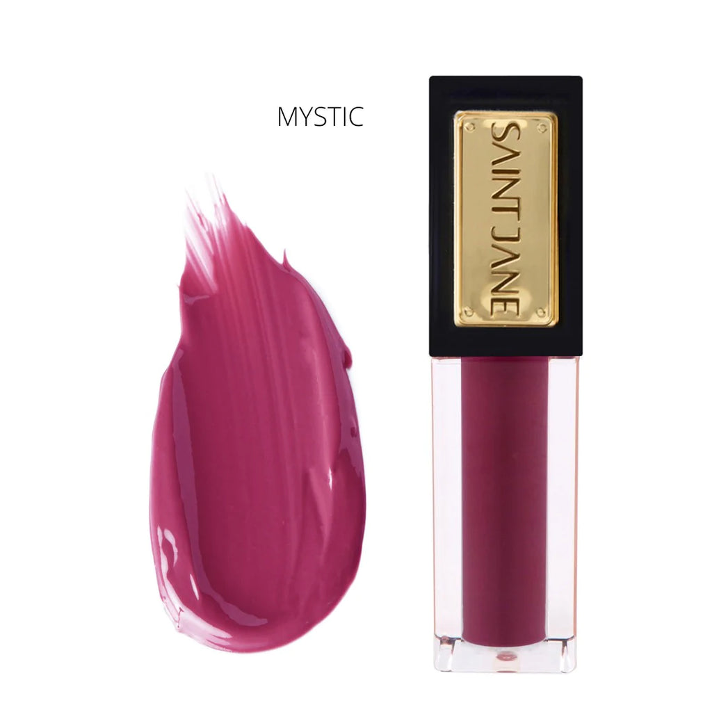 A swatch of "mystic" shade lipstick next to its corresponding tube with gold label.