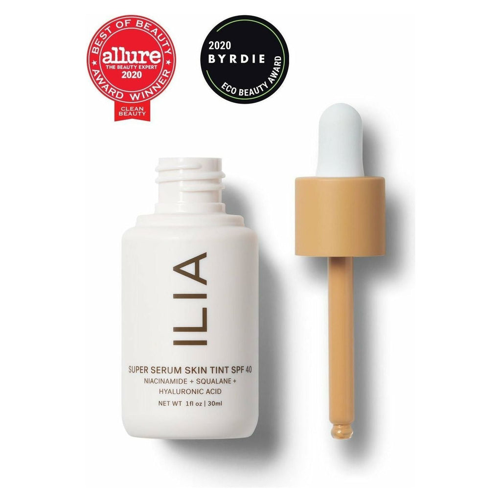 A bottle of ilia super serum skin tint spf 40 with its dropper applicator, displaying awards from allure and byrdie for beauty excellence.